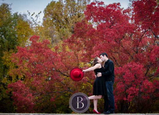 engagement photos kiss with beautiful red trees in the background