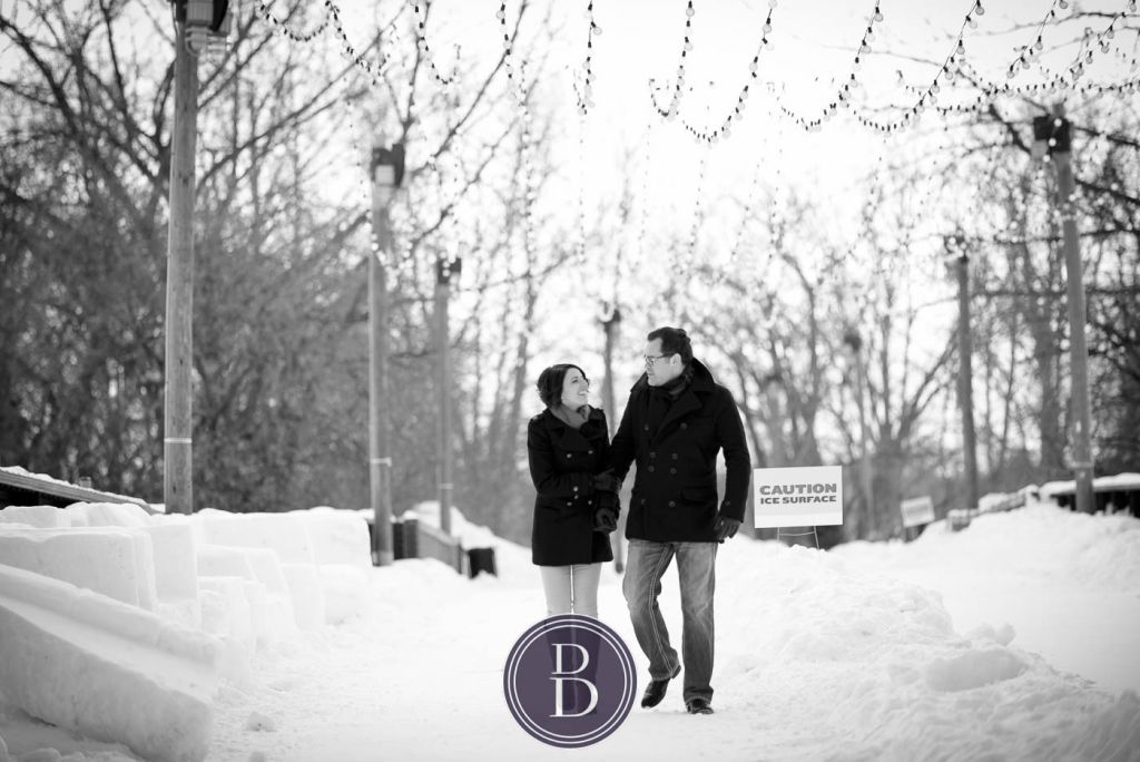 winter photo engagement session couple with smiles walking down the bridge the Forks Winnpeg
