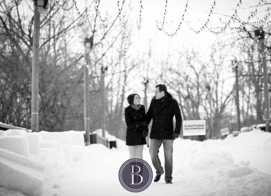 winter photo engagement session couple with smiles walking down the bridge the Forks Winnpeg