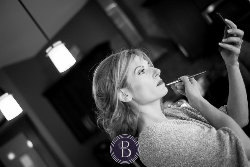 An elegant blue winter wedding. Bride getting ready on hear wedding day with touch ups of makeup