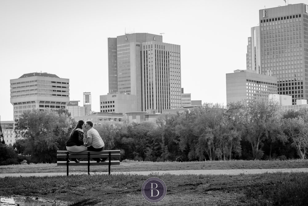 engagement photos sunset winnipeg downtown kiss on a bench
