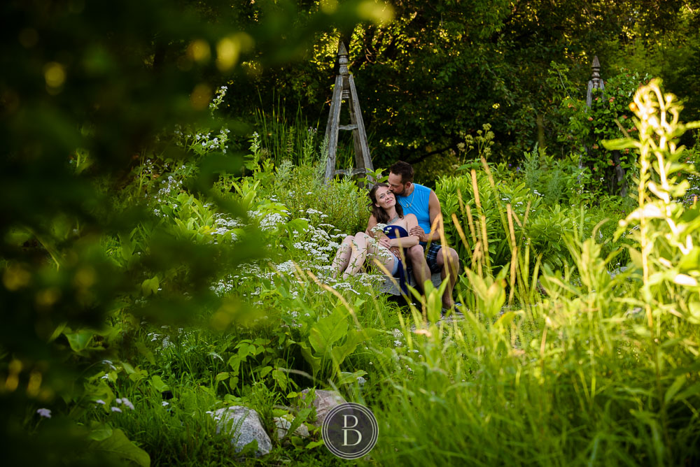 couple sitting on bench flower garden evening engagement session st norbert monastery grounds