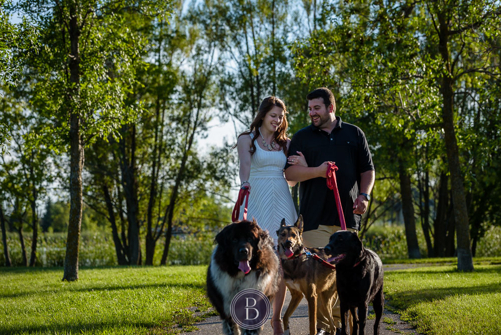 couple and their dogs on walk in park