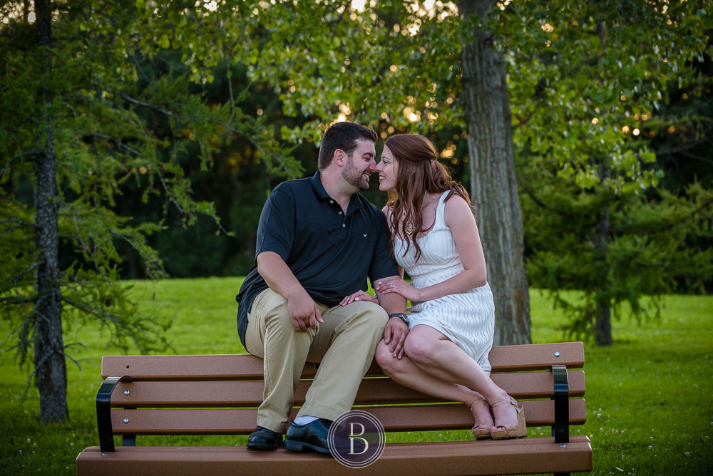 Engaged couple on a bench in love and smiles