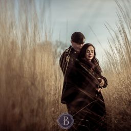 Engaged couple hugging in love tall prairie grass Assiniboine park