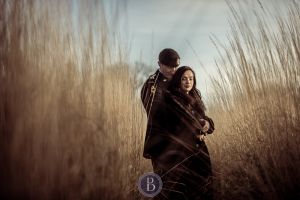 Engaged couple hugging in love tall prairie grass Assiniboine park