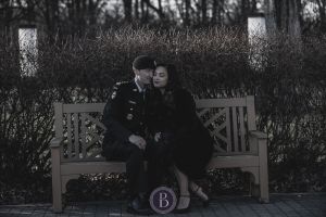 Engaged Winnipeg couple sitting on bench Assiniboine Park