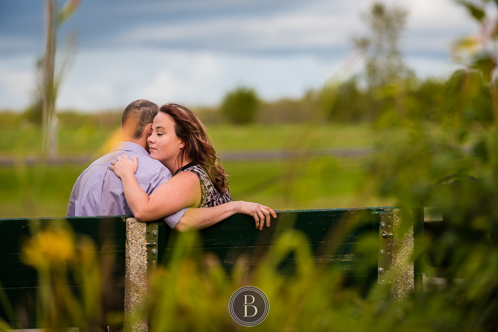 engaged couple in park in love bench