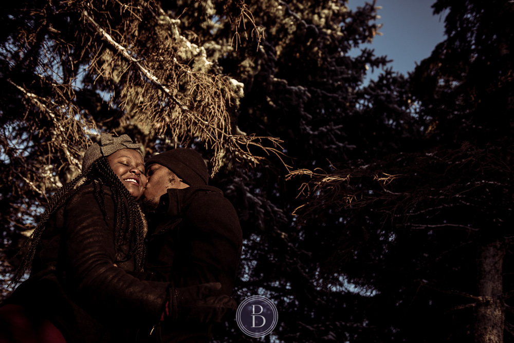 Winnipeg winter engagement photo session kiss in trees The Forks