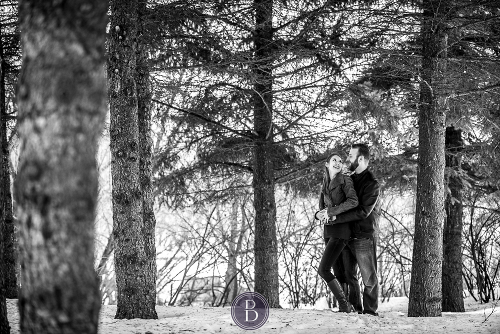 engaged couple smiles in love in trees