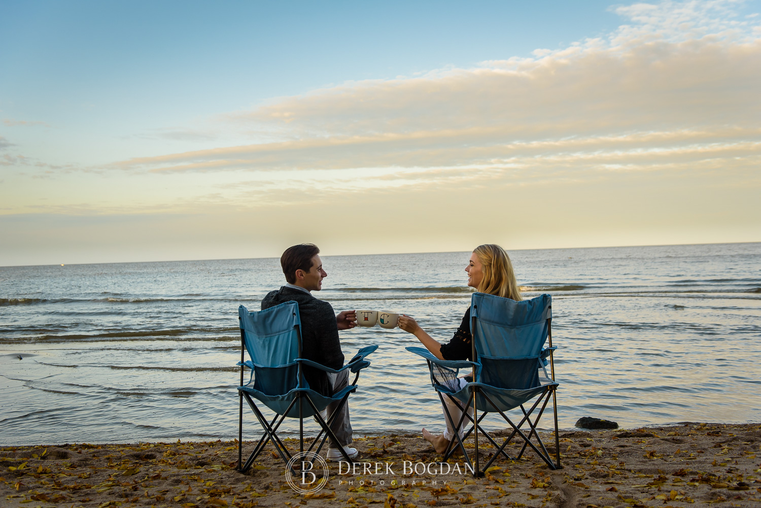 Gimli beach engagement photo session couple sitting by the water coffee mugs