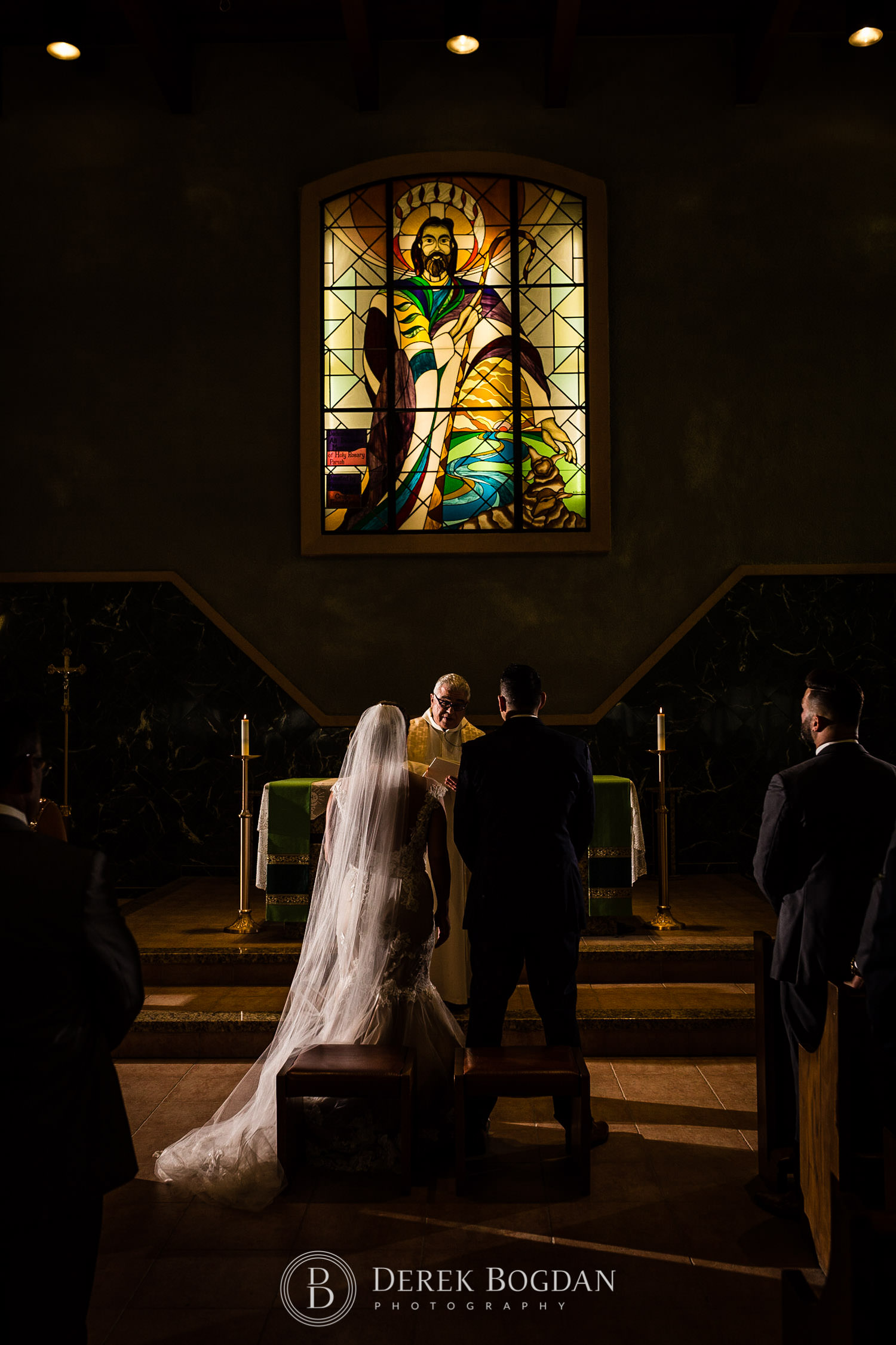 dramatic portrait bride and groom stained glass catholic wedding ceremony Winnipeg