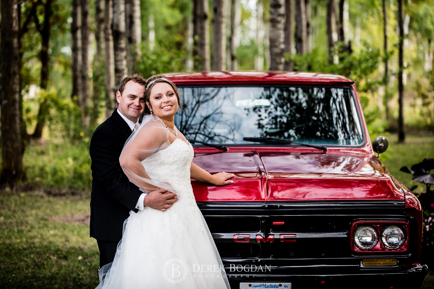 bride and groom by red truck portrait