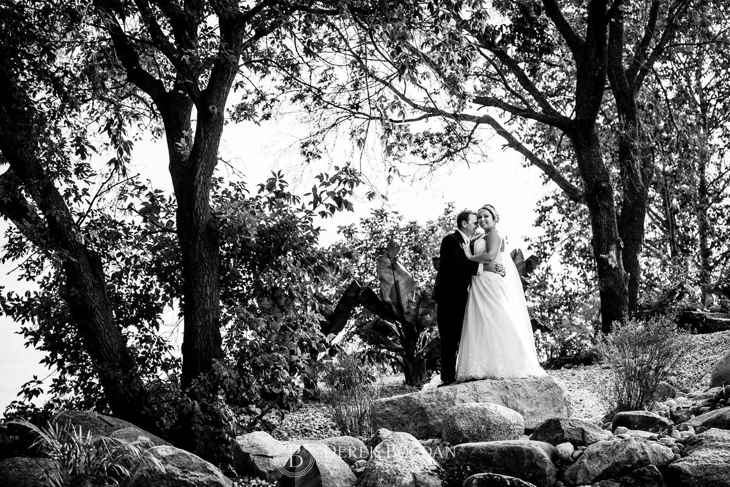 groom with bride outdoor creative portrait rocks