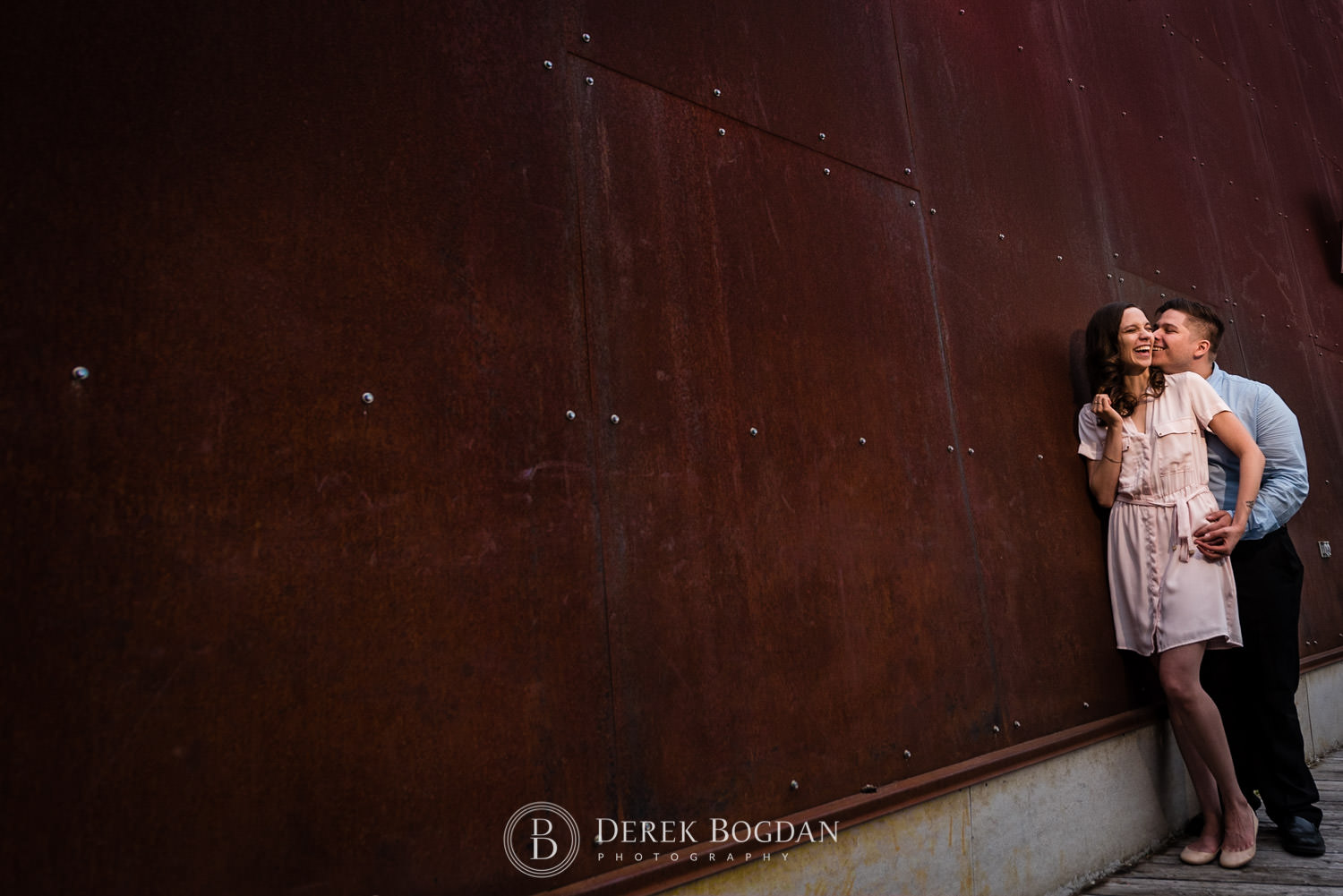 Evening engagement session by rustic wall Winnipeg couple