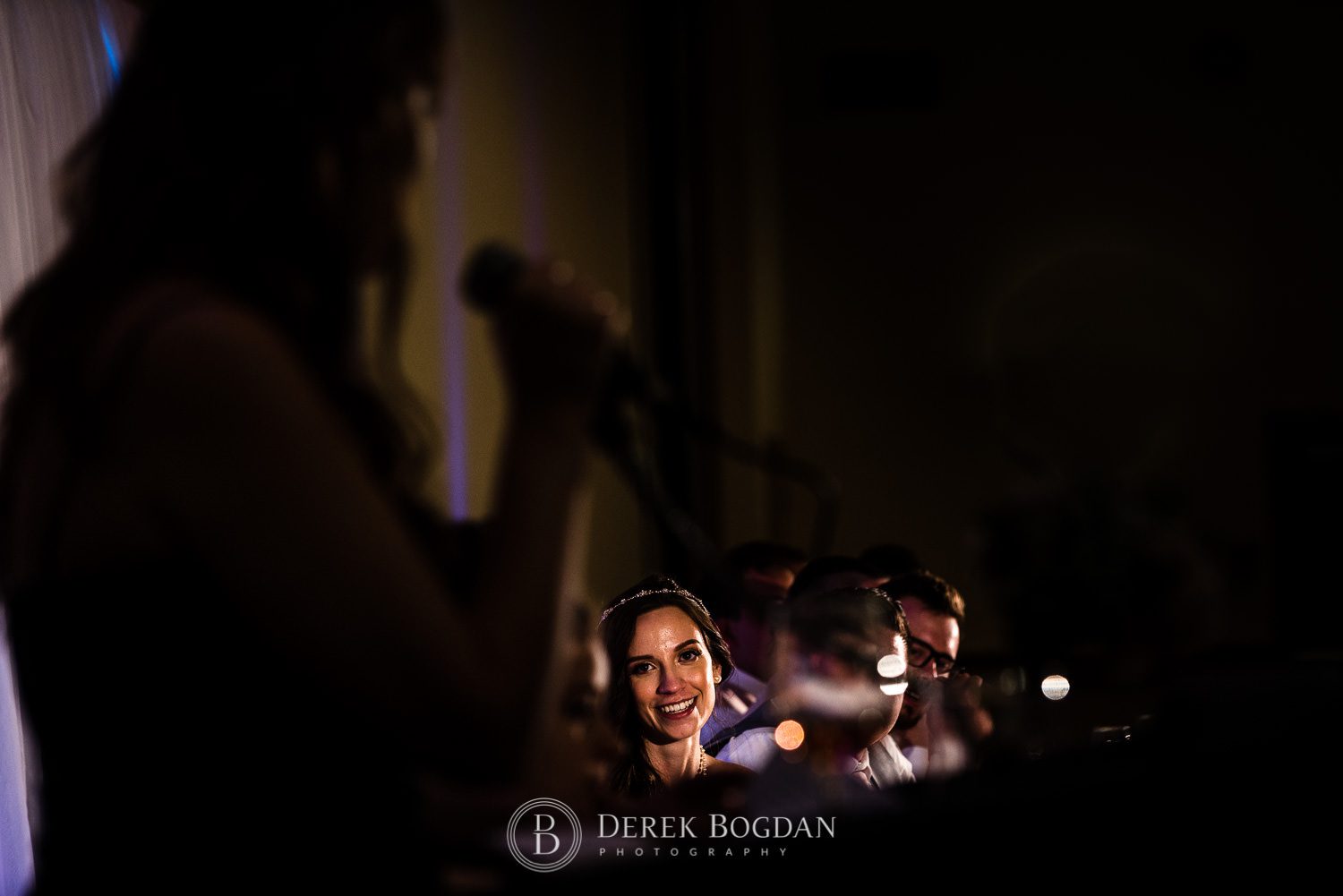 Bride looks on during speeches Victoria Inn Winnipeg wedding reception